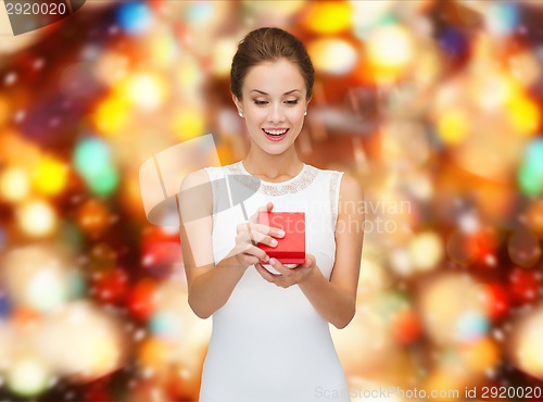 Image of smiling woman holding red gift box