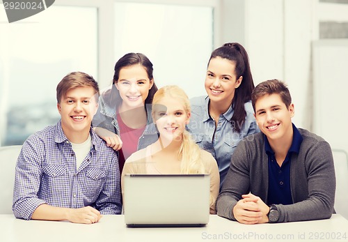 Image of smiling students with laptop at school
