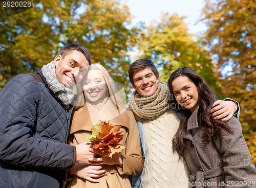 Image of group of smiling men and women in autumn park