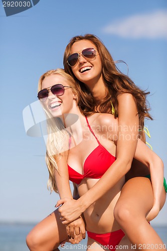 Image of two smiling young women on beach