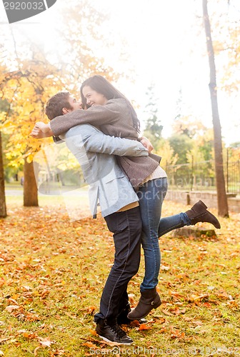 Image of smiling couple hugging in autumn park