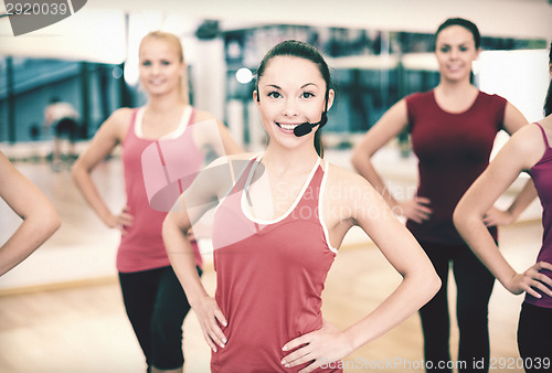 Image of group of smiling people exercising in the gym