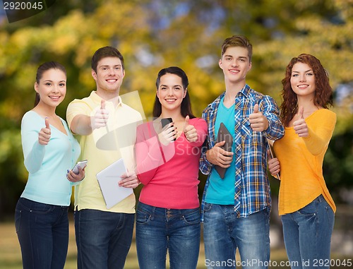 Image of group of teenagers with smartphones and tablet pc