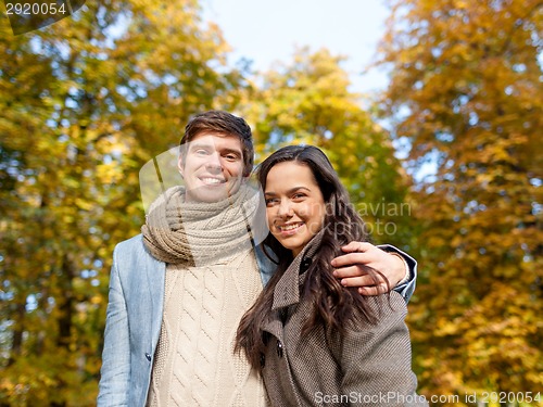 Image of smiling couple hugging in autumn park