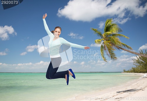 Image of smiling young woman jumping in air