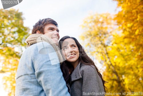 Image of smiling couple hugging in autumn park