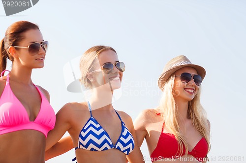 Image of group of smiling young women in sunglasses