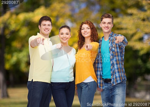 Image of group of smiling teenagers pointing fingers on you