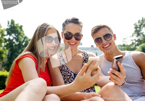 Image of smiling friends with smartphone making selfie