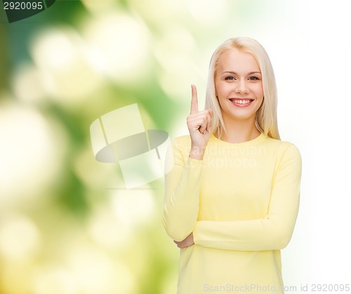 Image of smiling woman pointing her finger up