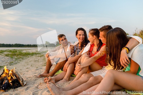 Image of smiling friends in sunglasses on summer beach