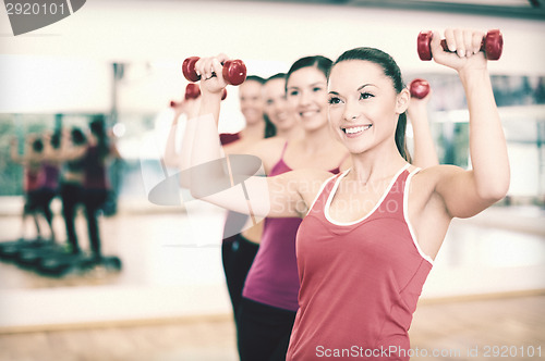 Image of group of smiling people working out with dumbbells