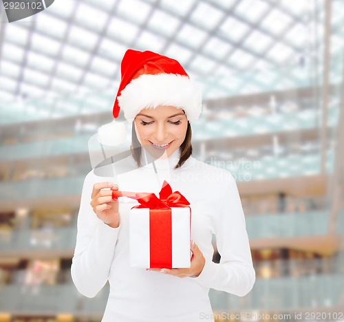 Image of smiling woman in santa helper hat with gift box