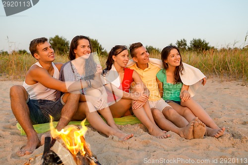 Image of smiling friends in sunglasses on summer beach