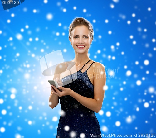 Image of smiling woman in evening dress with smartphone