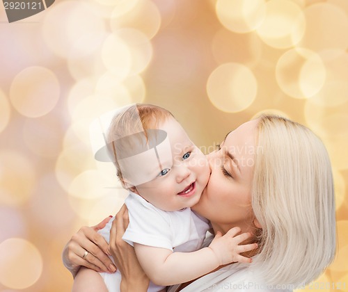 Image of happy mother kissing smiling baby