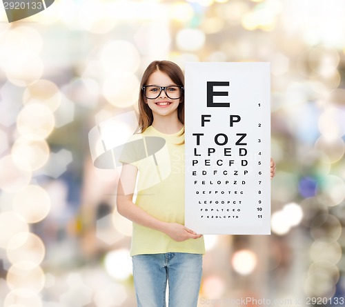 Image of little girl in eyeglasses with eye checking chart