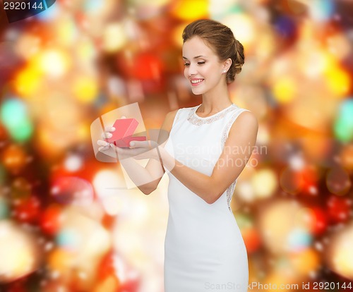 Image of smiling woman holding red gift box