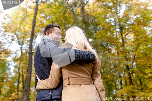 Image of smiling couple hugging in autumn park