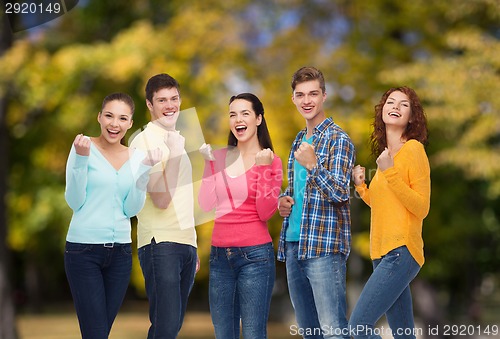 Image of group of smiling teenagers over green park