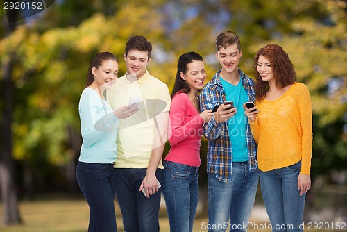 Image of group of smiling teenagers with smartphones