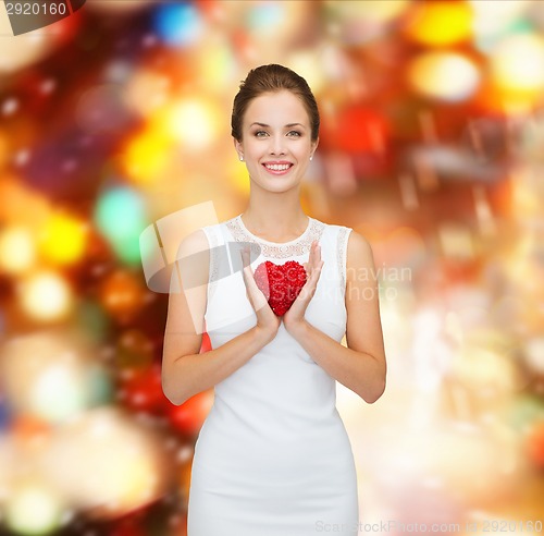 Image of smiling woman in white dress with red heart