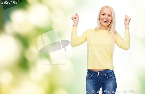 Image of laughing young woman with hands up