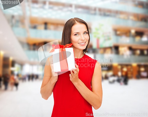 Image of smiling woman in red dress with gift box