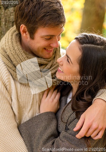 Image of smiling couple hugging in autumn park