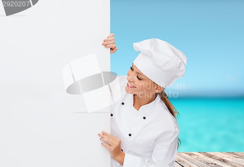 Image of smiling female chef with white blank board