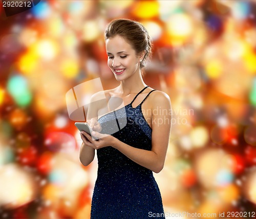 Image of smiling woman in evening dress with smartphone