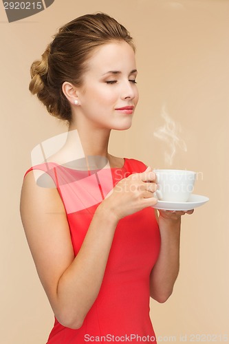 Image of smiling woman in red dress with cup of coffee