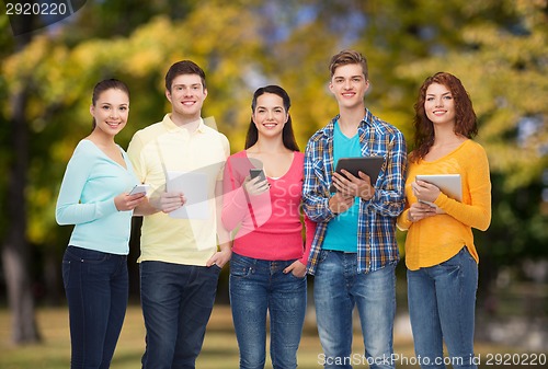 Image of group of teenagers with smartphones and tablet pc