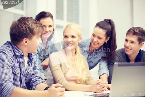 Image of group of smiling students with laptop at school