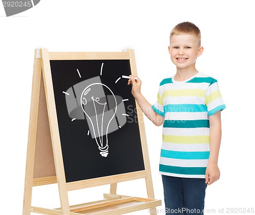 Image of smiling little boy with blank blackboard