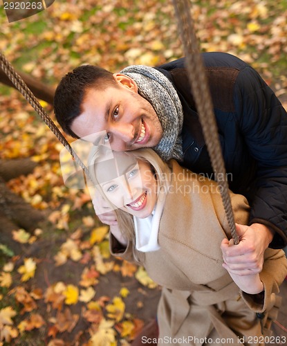 Image of smiling couple hugging in autumn park