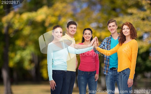 Image of group of smiling teenagers over green park