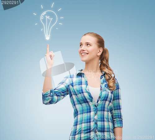 Image of smiling young woman pointing finger up