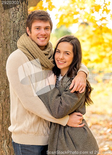 Image of smiling couple hugging in autumn park