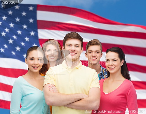 Image of group of smiling teenagers over american flag