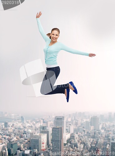 Image of smiling young woman jumping in air