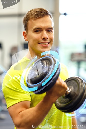 Image of smiling man with dumbbell in gym