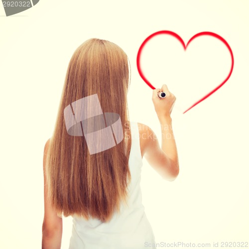 Image of girl in shirt drawing heart on virtual screen