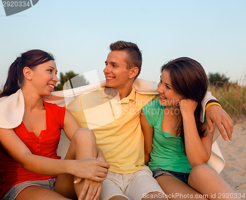 Image of smiling friends in sunglasses on summer beach