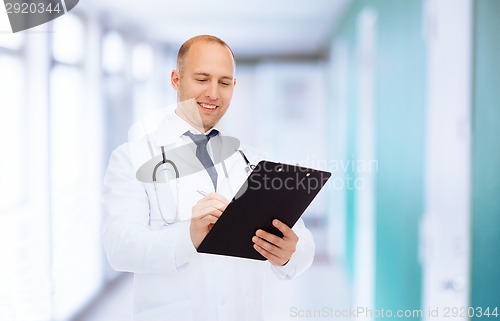 Image of smiling male doctor with clipboard and stethoscope