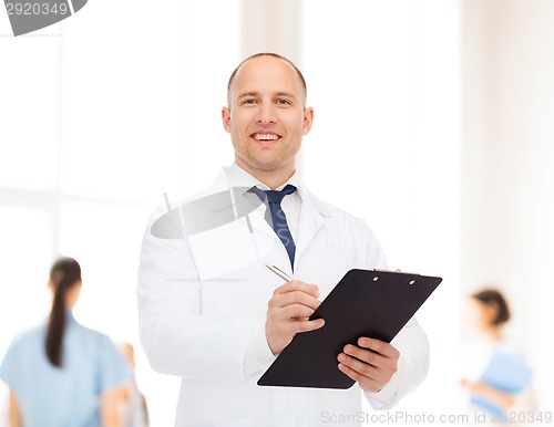 Image of smiling male doctor with clipboard