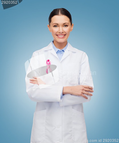 Image of smiling female doctor with cancer awareness ribbon