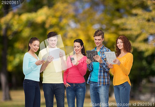 Image of group of teenagers with smartphones and tablet pc