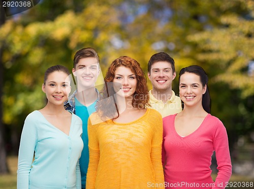 Image of group of smiling teenagers over green park