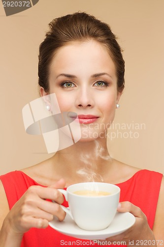 Image of smiling woman in red dress with cup of coffee